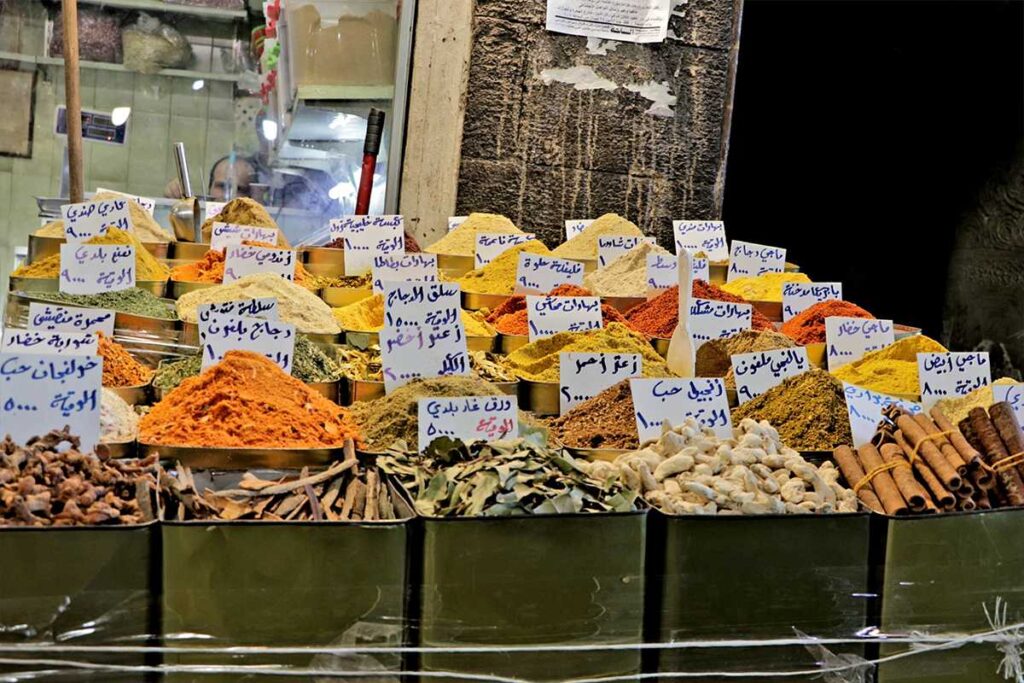 Explore Al-Buzuriyyeh Souq in Old Damascus: a short spice and herb street with malban, qamar al-din, rose water, and Khan As'ad Pasha. Tips on what to buy.
