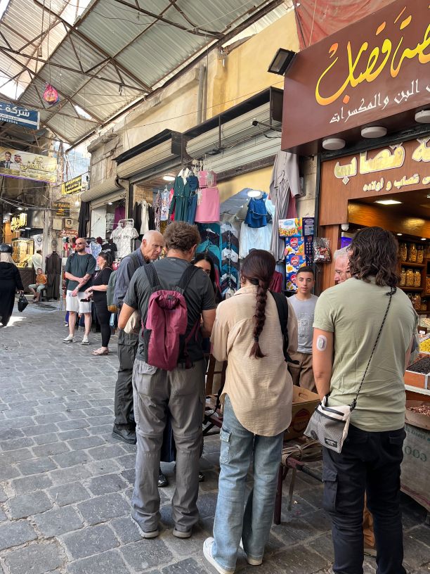Syrian Guides visitors in a traditional market of Aleppo